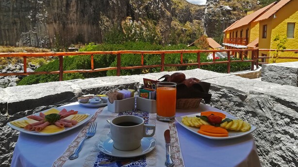A table set with breakfast, overlooking a mountainous landscape. - El Refugio Hotel Colca (Chivay)