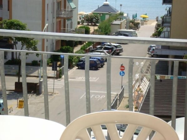 A balcony with a view of a street and buildings, including a stop sign and a pedestrian crossing. - Hotel Emperador (Jesolo)