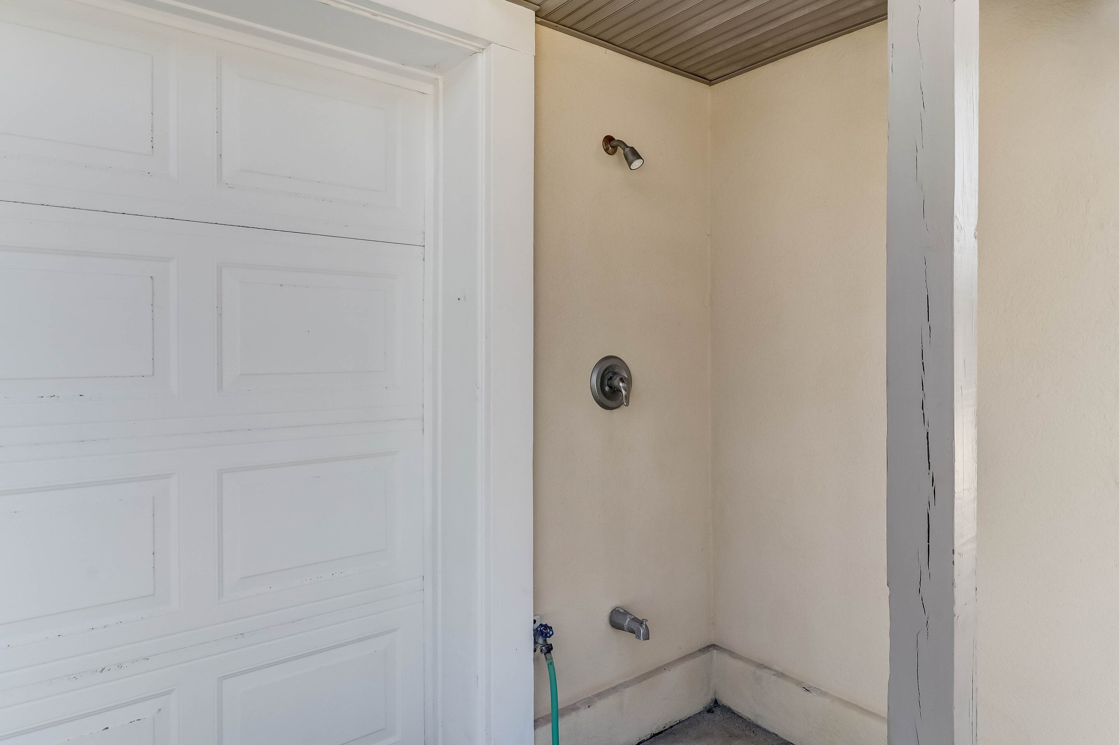 A garage door and a corner with a wall-mounted light fixture and a door handle.