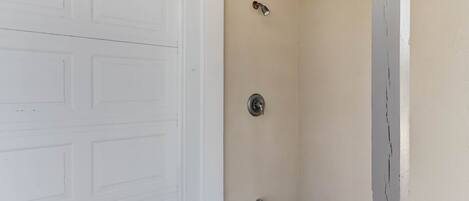 A garage door and a corner with a wall-mounted light fixture and a door handle.