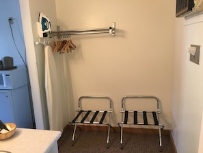 A hotel room with a microwave, ironing board, and two metal drying racks. - Golden Eagle Inn (Jackson)