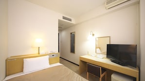 A hotel room with a bed, desk, chair, television, and a small refrigerator. - Sun Hotel Hachioji (Hachioji)