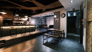 Una cocina moderna con barra, techo de madera y un reloj en la pared.