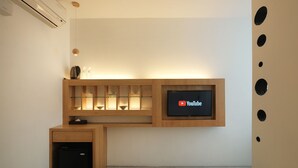 Una cocina moderna con un mueble de madera empotrado, un lavavajillas negro y un televisor de pantalla plana montado en la pared mostrando el logotipo de YouTube.