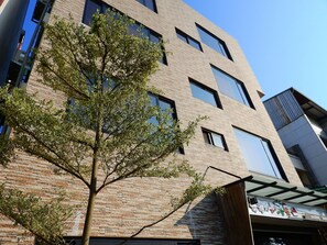 A multi-story building with a brick facade, large windows, and a tree in front. - Anping Western-style House (Tainan)