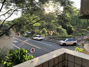 A road with cars parked on the side, surrounded by trees and greenery. - Anping Western-style House (Tainan)