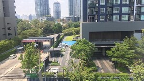 A modern urban street with high-rise buildings, a gas station, and a parking lot. - Casa Asara (Bangkok)