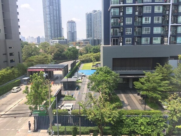 Una strada moderna in città, con edifici alti, una stazione di servizio e un parcheggio.