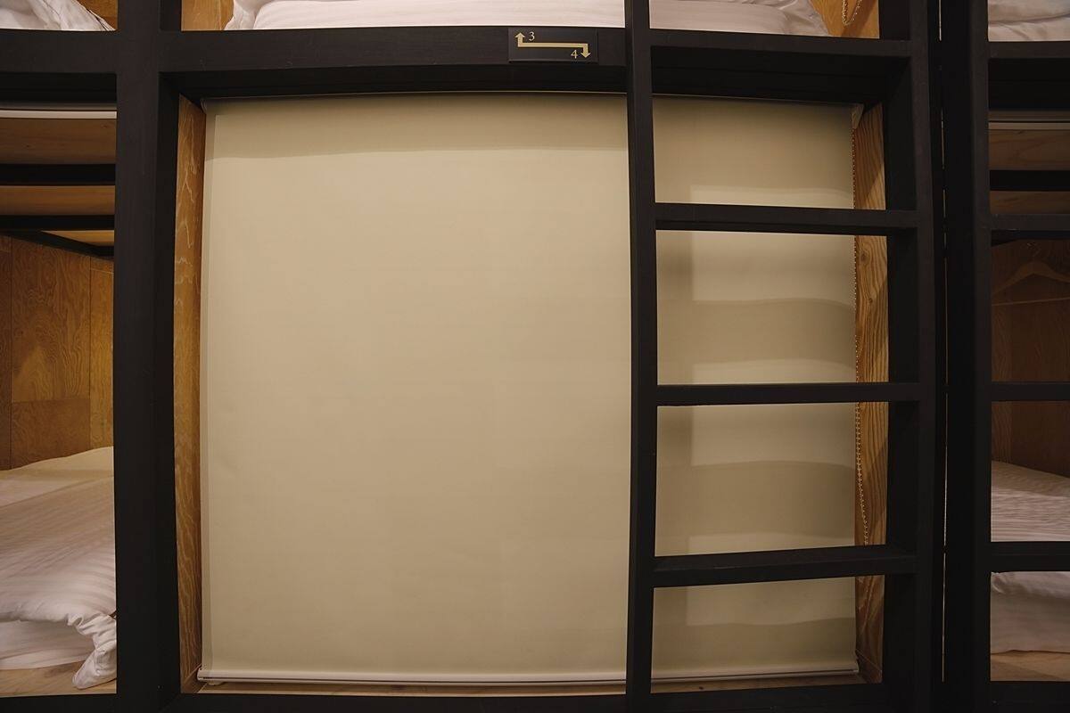 A bunk bed with a pull-out desk and a small window.