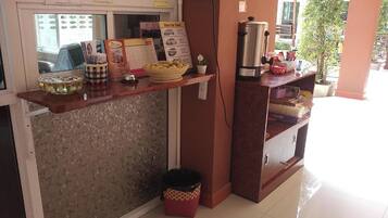 A reception desk with a computer, a calendar, and various items on the counter.