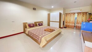 A bedroom with a bed, a wardrobe, an air conditioning unit, and a desk. - P&P Place (Kanchanaburi)