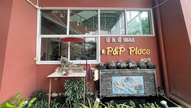 A storefront with a sign reading "P&P Place" and a display of potted plants. - P&P Place (Kanchanaburi)