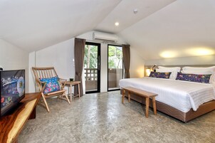 Een slaapkamer met een bed, een stoel, een tafel en een televisie.