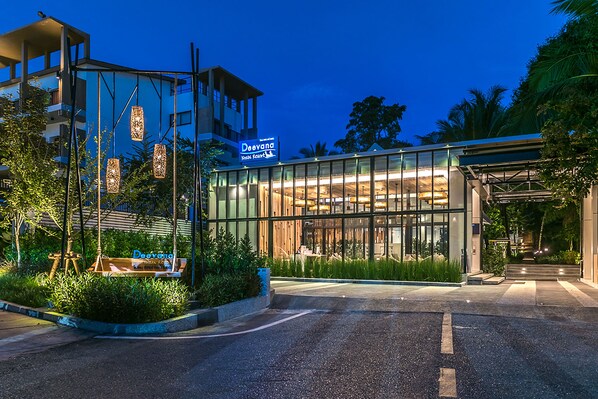A modern hotel with a glass facade, a signboard, and a well-lit entrance. - Deevana Krabi Resort (Krabi)