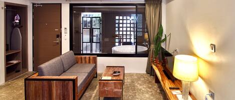 A modern living room with a sofa, coffee table, and a TV on a wooden stand.