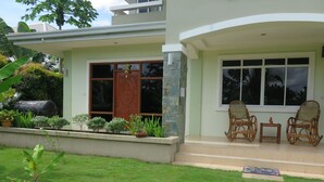 A modern house with a front porch, stone steps, and a small garden. - Oasi Fiore Bed and Breakfast (Dauis)