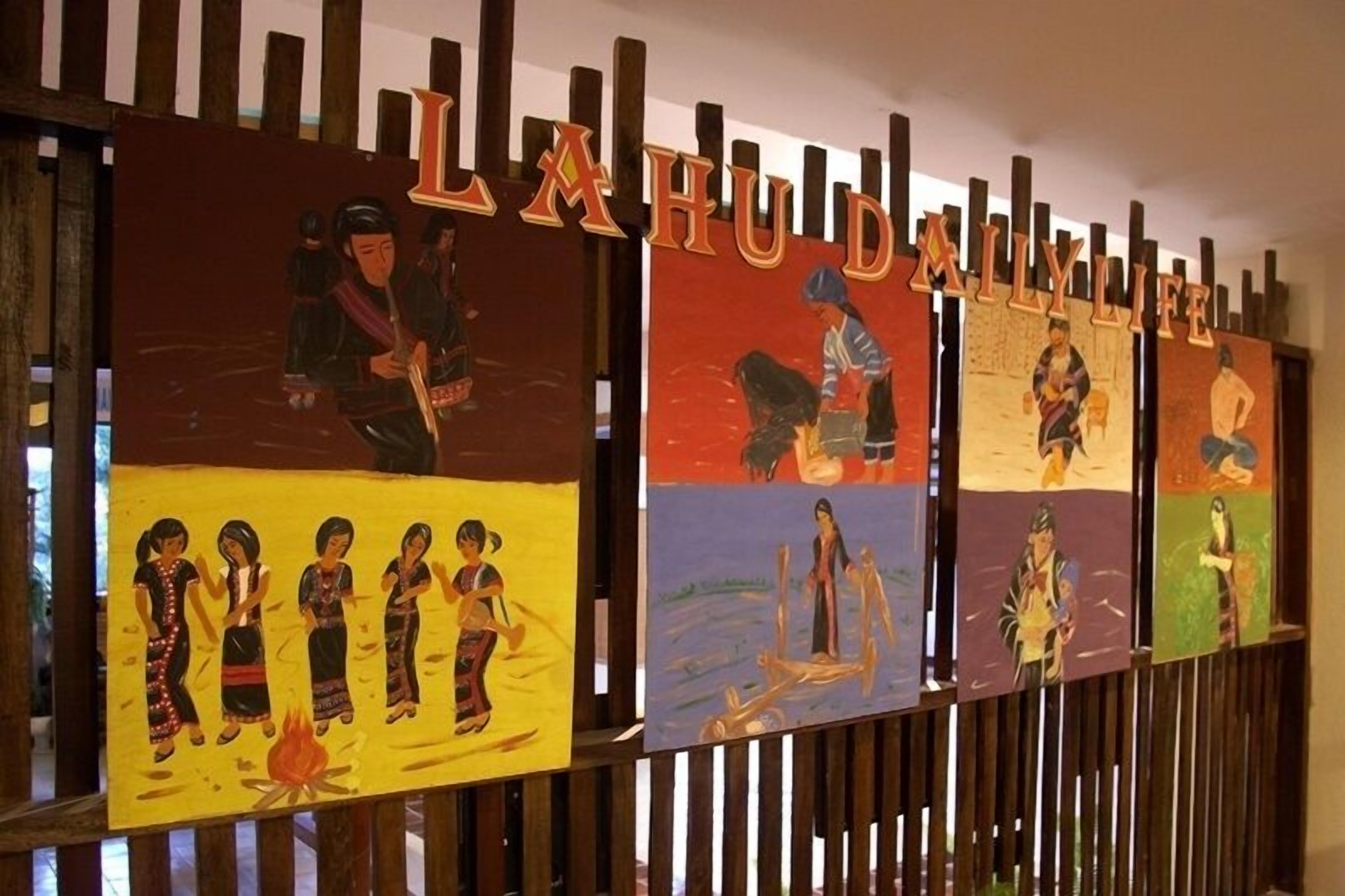 Pared con listones de madera y pinturas coloridas que representan escenas tradicionales.
