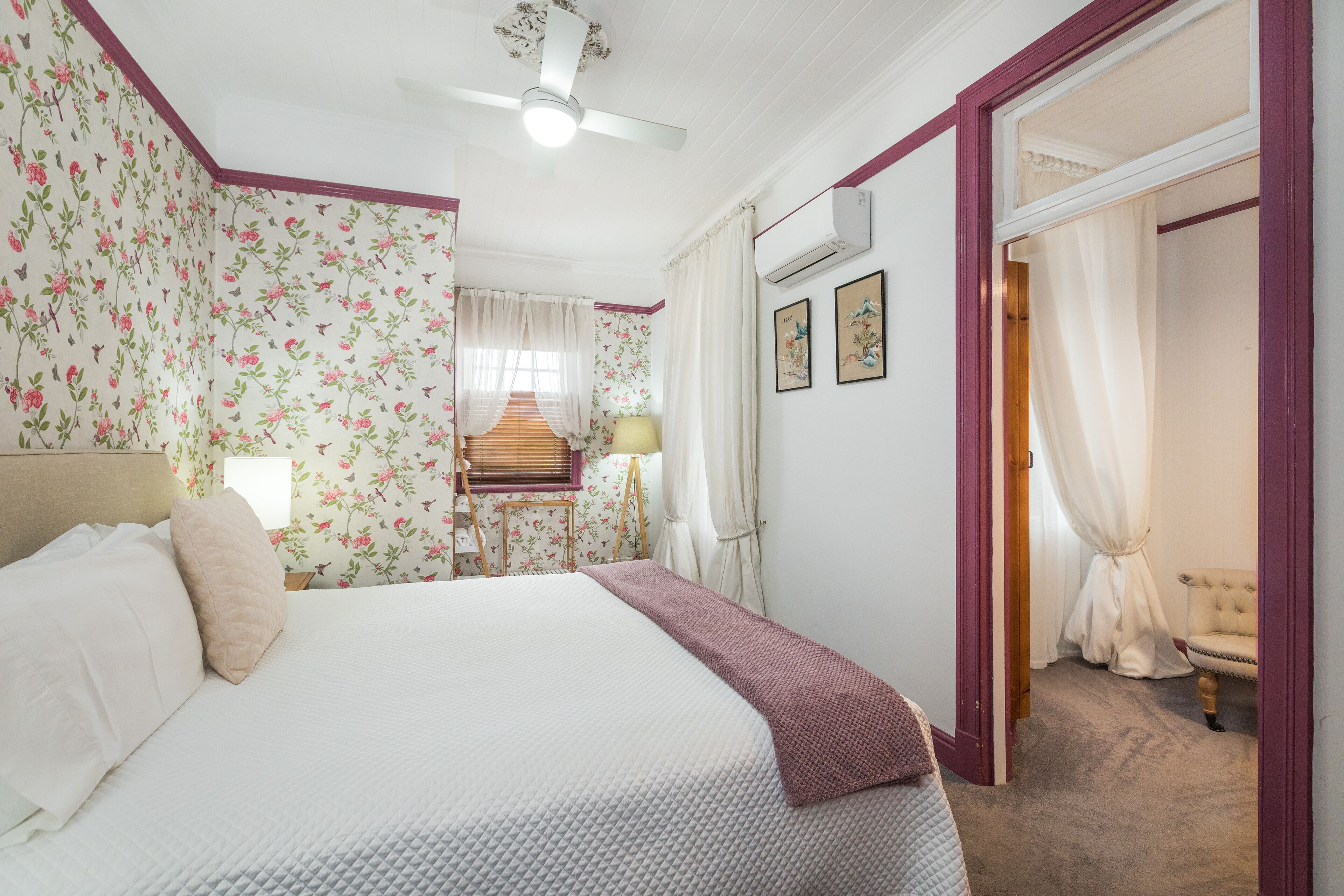 A bedroom with a bed, a nightstand, a lamp, and a chair.