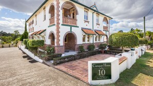 Una casa grande de dos pisos con un balcón destacado, fachada de ladrillo y un letrero que indica que es el número 10 de la calle Salisbury.