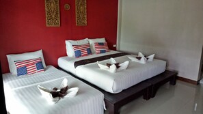 A hotel room with two beds, red walls, and American flag pillows.