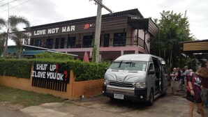 A building with a sign reading "LOVE NOT WAR" and a vehicle parked in front.