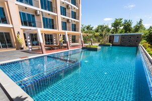 Una piscina al aire libre, sillones reclinables de piscina