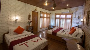 A hotel room with two beds, a wooden bench, a brick wall, and a wooden ceiling. - Teak Wood Hotel (Nyaungshwe)