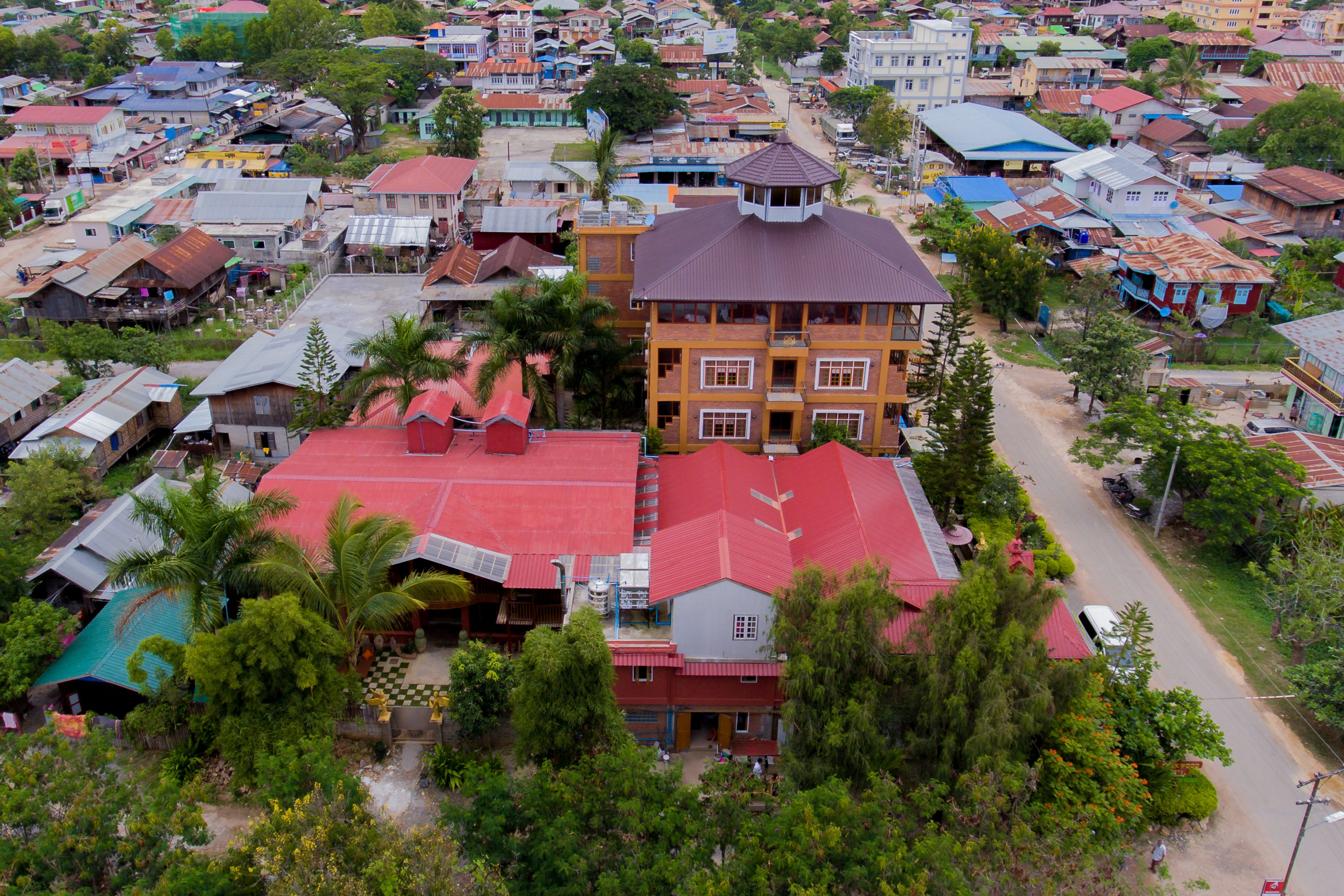 An aerial view of a residential area with a prominent multi-story building with a red roof and a central tower.