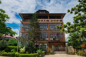 Um edifício de dois andares com uma placa que diz 'TEAK WOOD SPA SALON'.