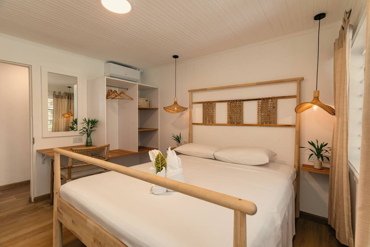 Ein ordentlich eingerichtetes Schlafzimmer mit einem hölzernen Bett, einem Schreibtisch und einem Kleiderschrank.