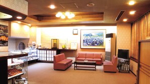 A hotel lobby with a reception desk, seating area, and a large framed picture on the wall. - Hotel Mimatsu (Nara)