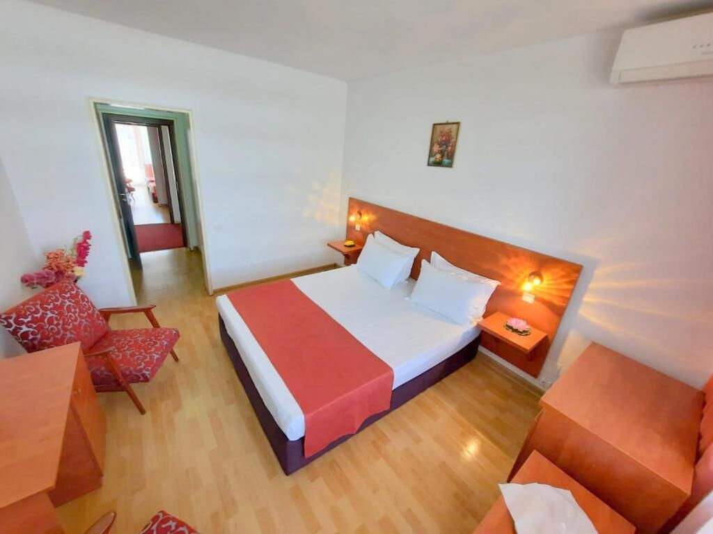 Una habitación de hotel con una cama, una mesita de noche, una silla y una pequeña mesa.