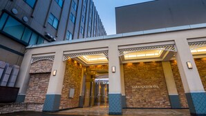Ein Hotel mit einer Steinfassade, einer Glastür und der Aufschrift 'NARAPLAZA HOTEL' über dem Eingang.