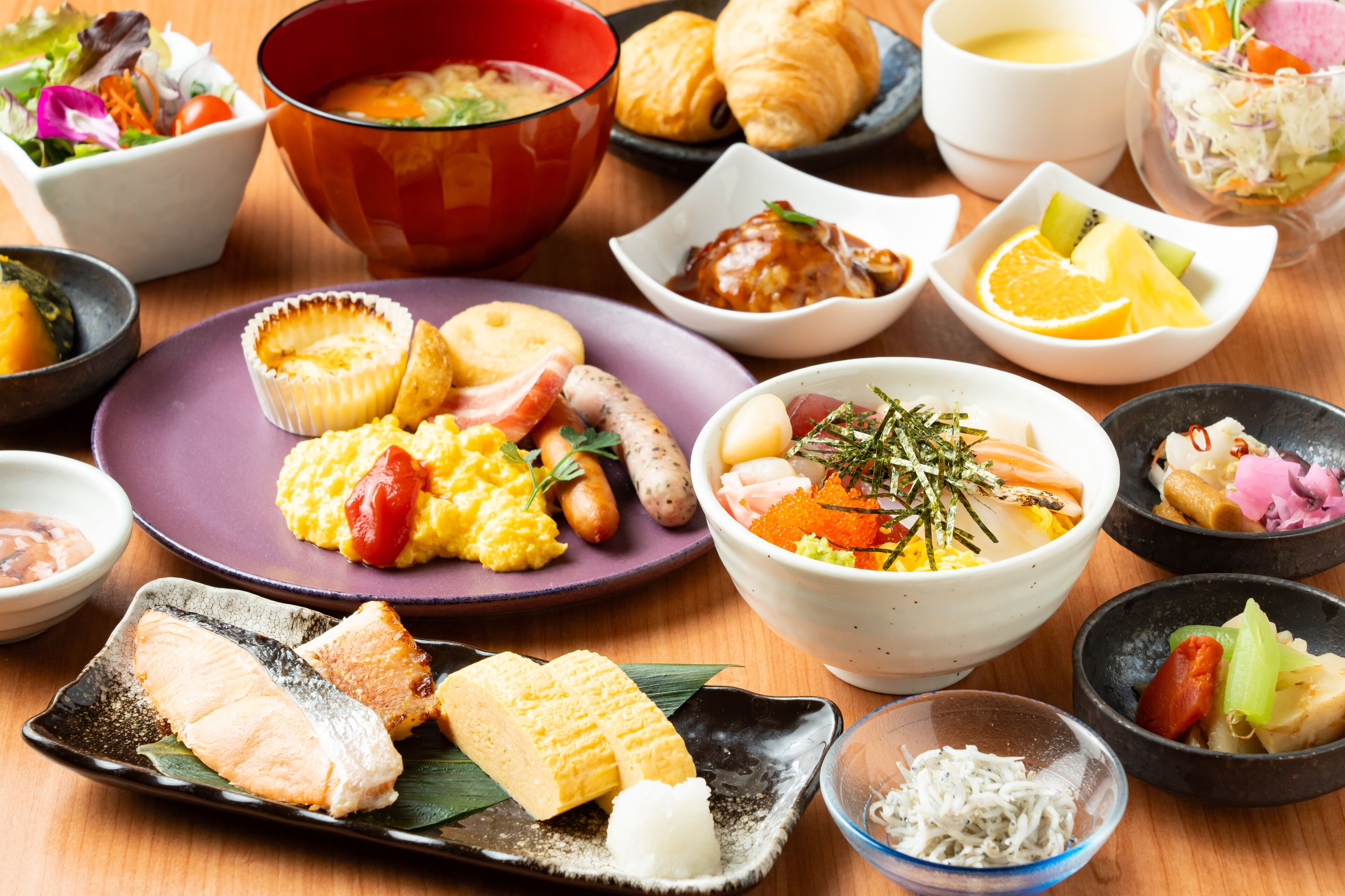 Variedad de platos que incluyen mariscos, verduras y pan, dispuestos sobre una mesa de madera.