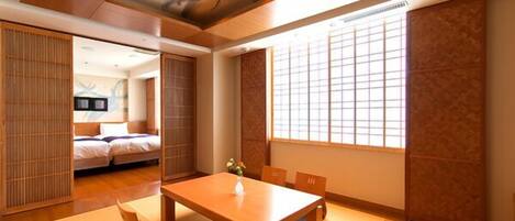 A traditional Japanese room with tatami flooring, a low wooden table, and sliding doors.