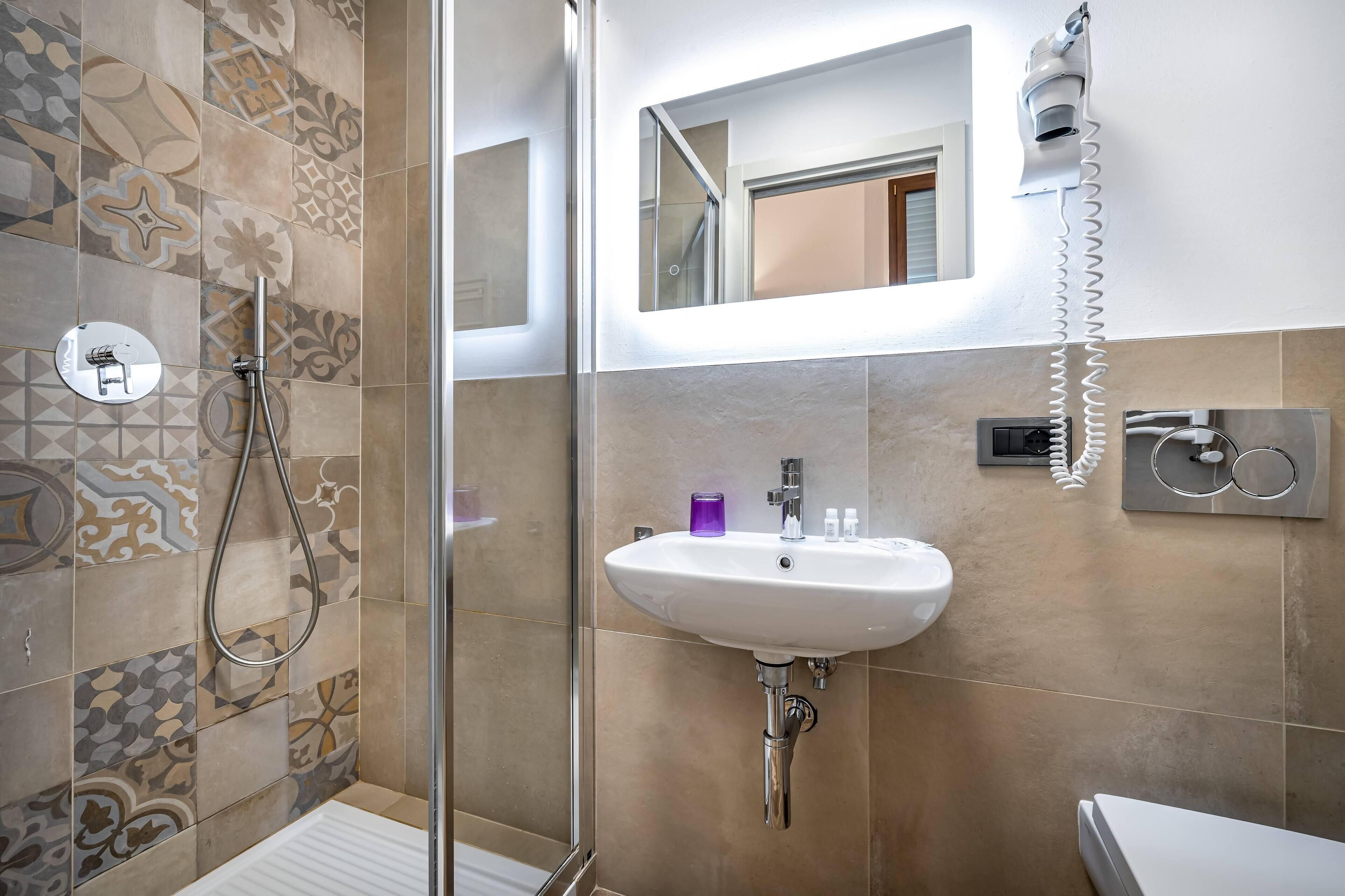 Une salle de bain avec une douche, un lavabo et des toilettes.