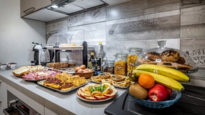 A buffet with various food items including fruits, pastries, and sandwiches. - B&B Lorenzo de' Medici (Florence)