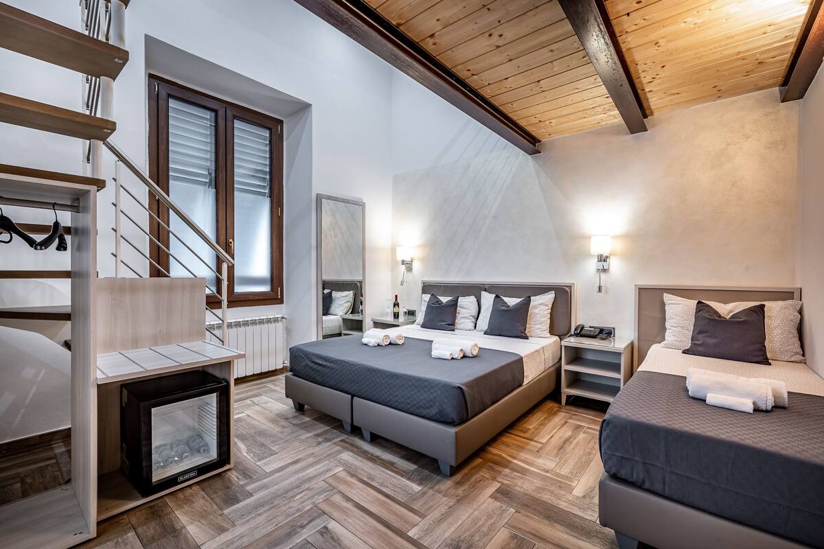 Une chambre moderne avec un lit de style industriel, un placard intégré et un petit coin salon.