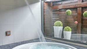 A hot tub with two glasses of red wine and a towel. - Gold Motel (Puxin)