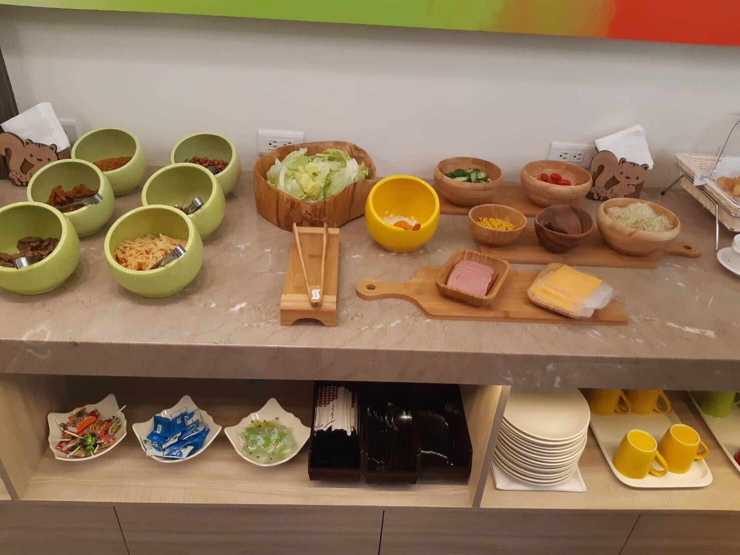 Un taulell de cuina amb diferents aliments i utensilis, com ara bols, un ganivet ferro i una taula de tallar.