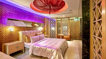 A modern bedroom with a large bed, a nightstand, and a decorative ceiling light.