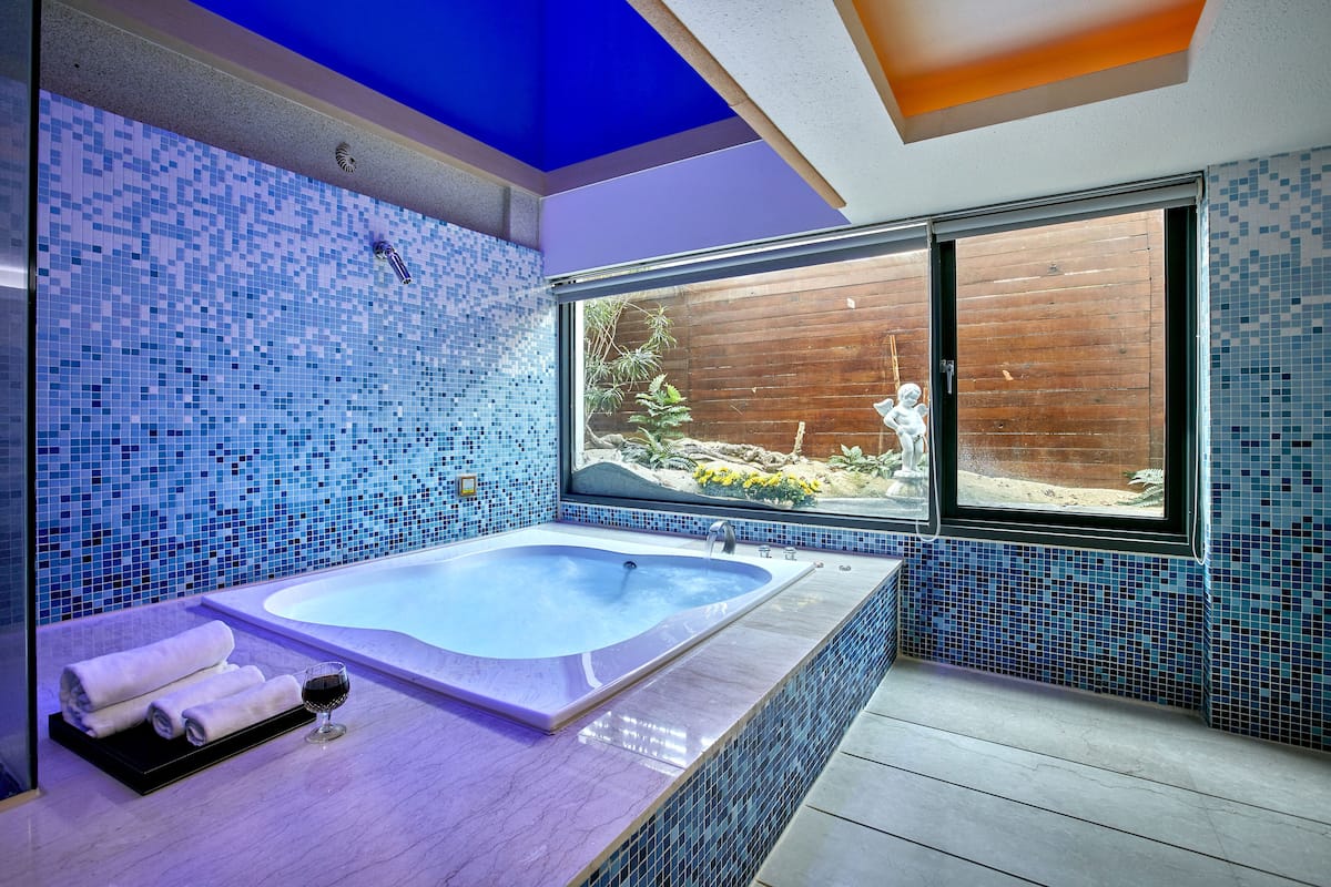 exclusive double room, 1 king bed, jetted tub, mezzanine | bathroom | shower, rainfall showerhead, free toiletries, hair dryer