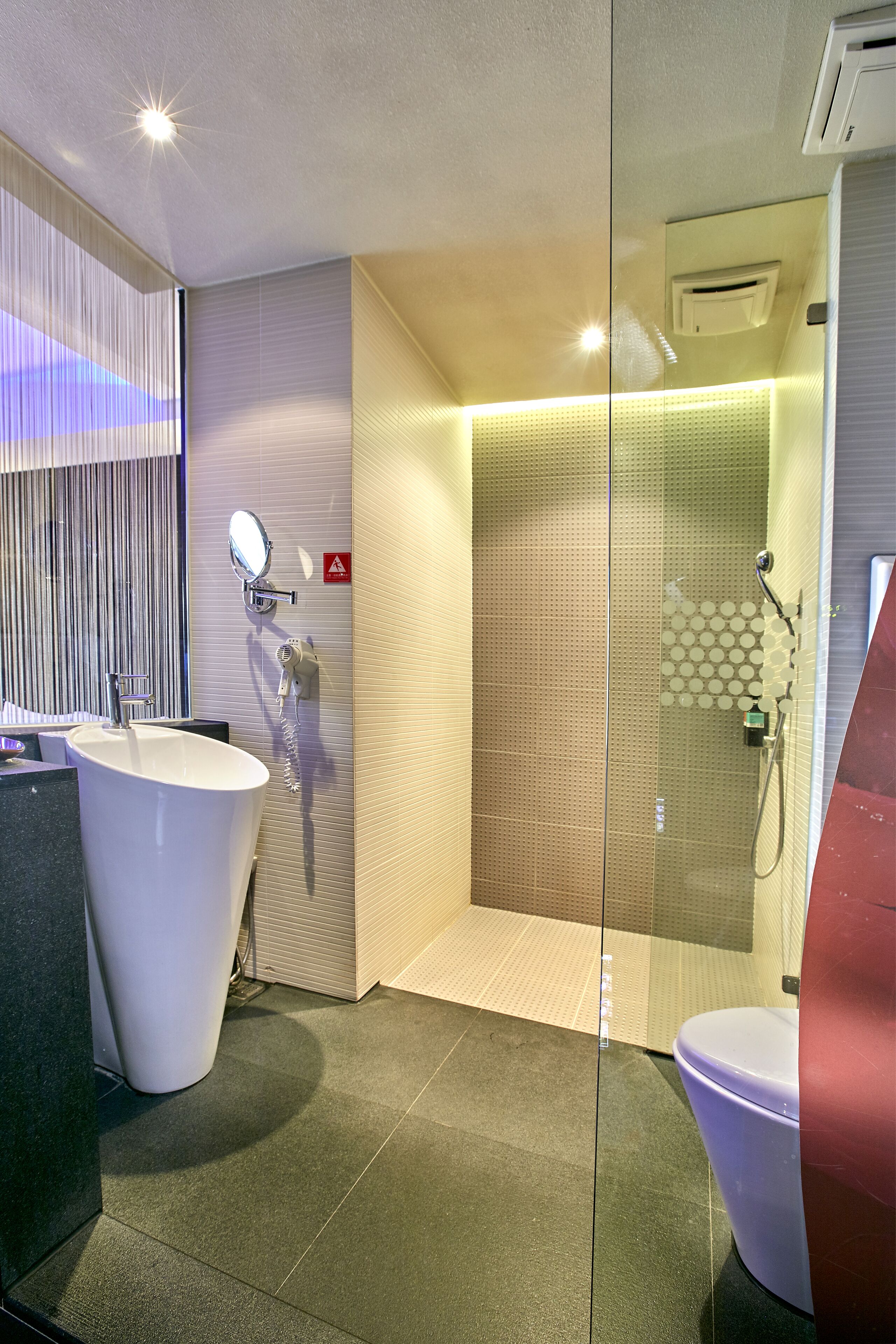 A modern bathroom with a freestanding bathtub, a glass-enclosed shower, and a toilet.