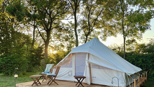 A tent with a deck, two chairs, a table, and a lantern. - Myregaard B&B & Apartments (Nexø)