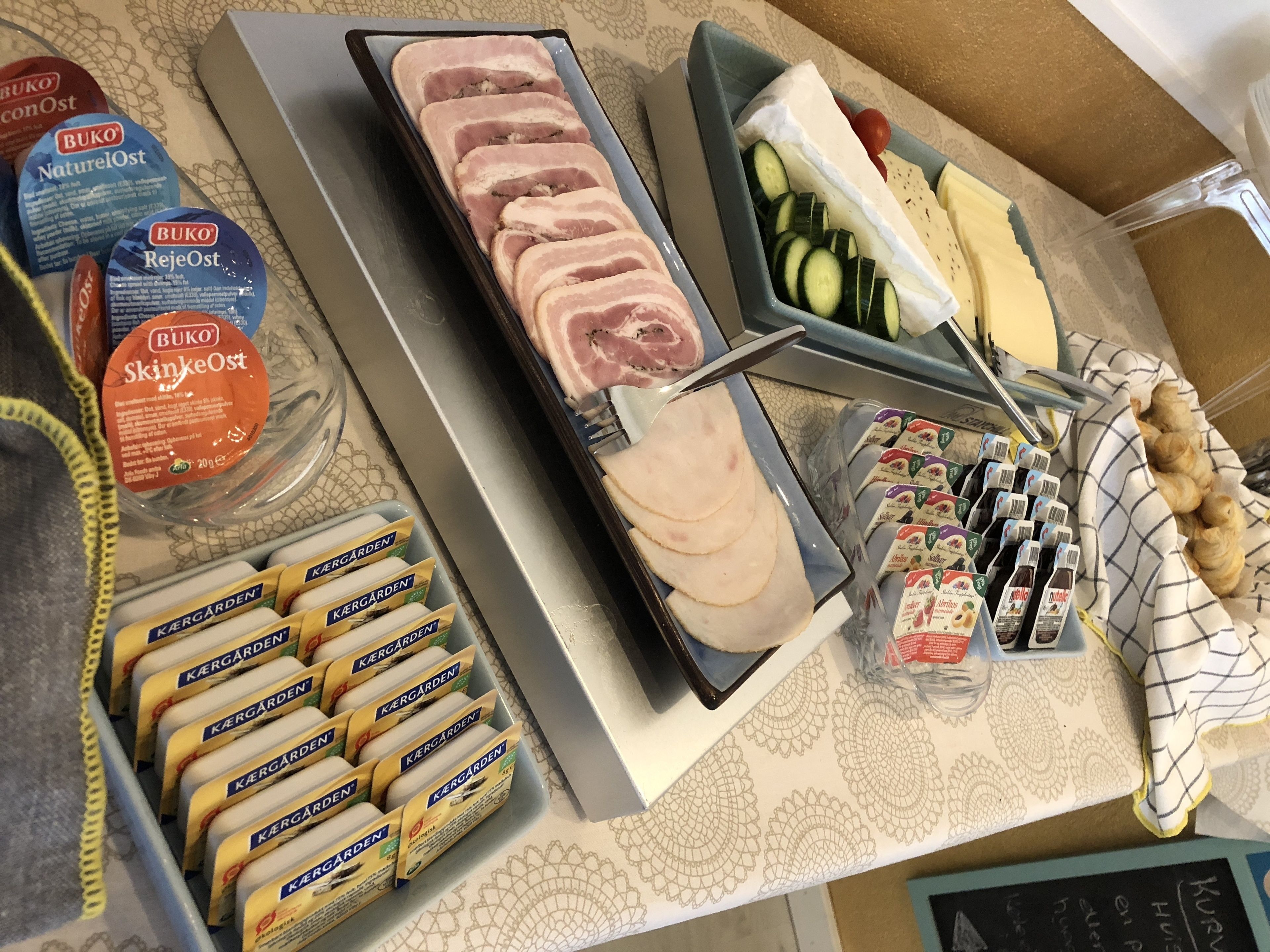A buffet with various food items including sliced meats, cheeses, and vegetables.