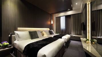 A modern hotel room with two beds, a large mirror, and a nightstand with a lamp.