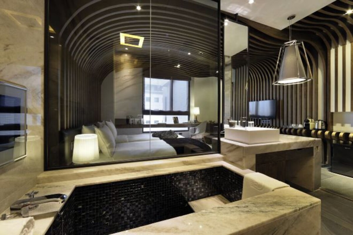 Un baño moderno con un espejo grande, una bañera y un tocador con lavabo.