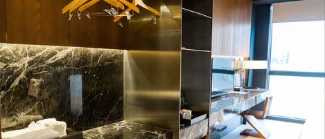 A modern bathroom with a marble countertop, a towel rack, and a mirror.