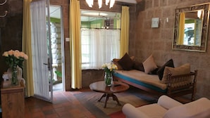 A cozy living room with a sofa, a round coffee table, and a vase of flowers. - Woodmere Serviced Apartments (Nairobi)