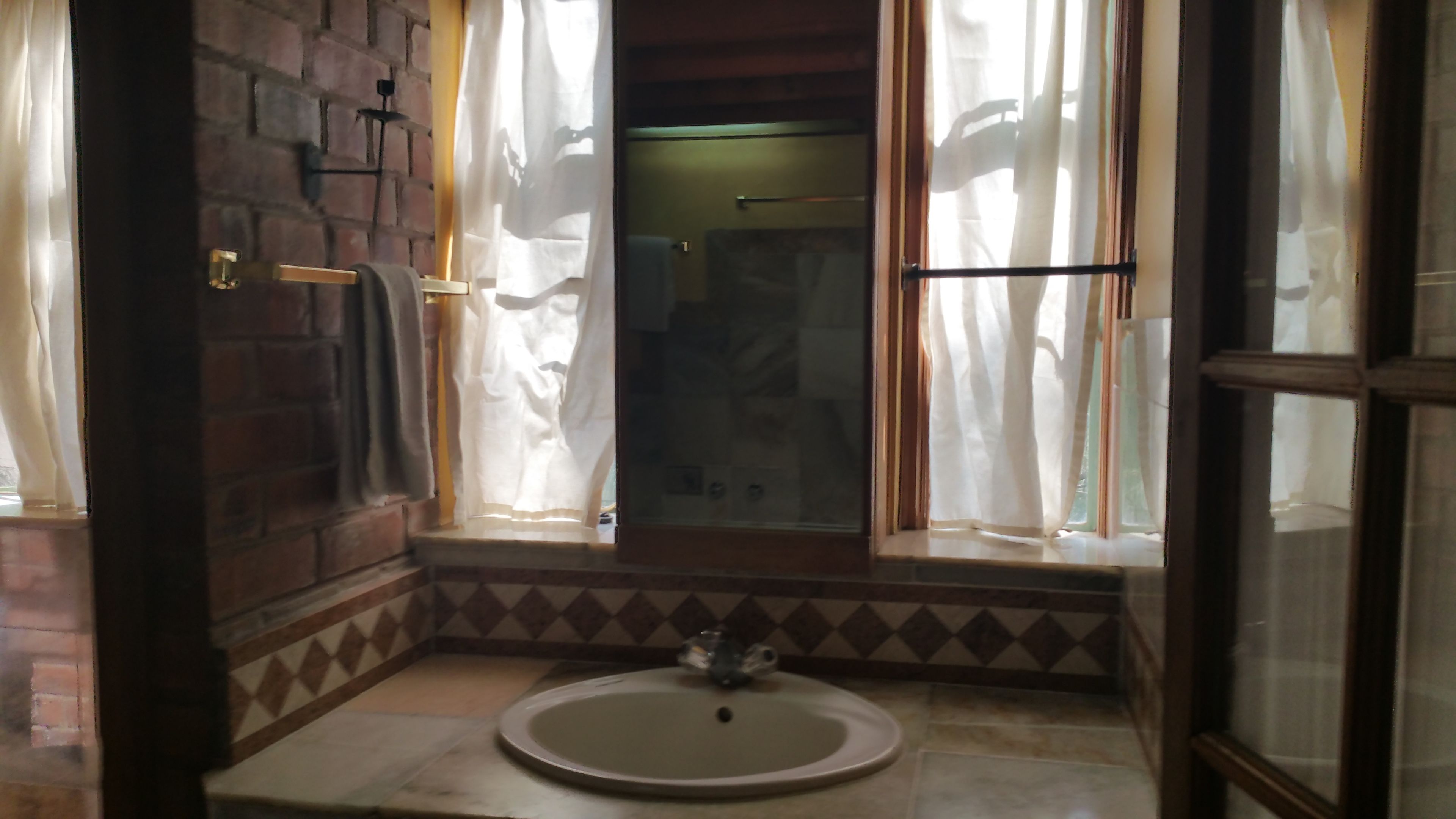 A bathroom with a small sink, a toilet, and a shower area.
